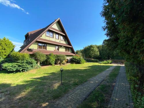 una casa con tejado abuhardillado y pasarela en Kampinówka, 