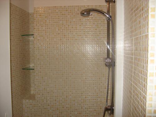 y baño con ducha y pared de azulejos. en La Casa del Teatro, en Sambuca di Sicilia