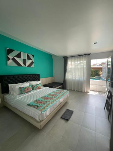 a bedroom with a large bed with a green wall at Lanta Corsica Hotel in Ko Lanta