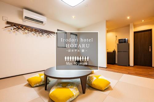 a room with a table and two yellow pillows at Irodori Hotel HOTARU in Fukuoka