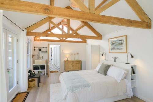 a bedroom with a white bed and wooden ceilings at The Artists Studio Private Parking Frome in Frome