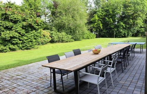 a wooden table and chairs on a patio at Domaine des Célestins - Captive des Sables in Bernay-en-Ponthieu