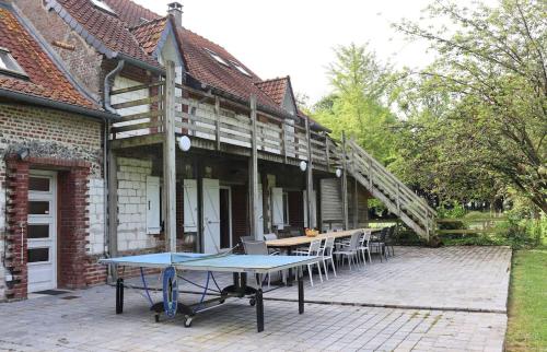 a patio with a table and chairs in front of a house at Domaine des Célestins - Captive des Sables in Bernay-en-Ponthieu