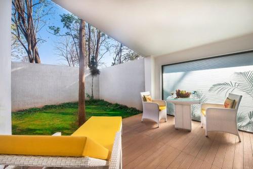 a living room with a yellow couch and a table at Royal Orchid Resort & Convention Centre, Yelahanka Bangalore in Bengaluru