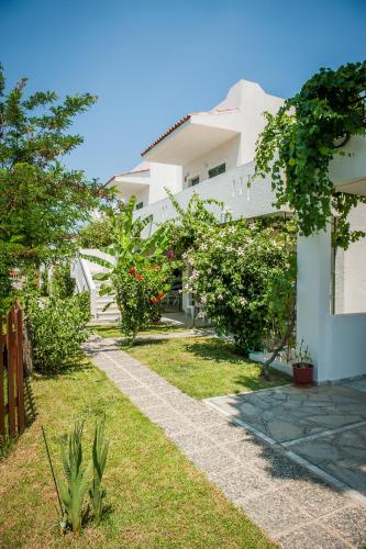 a white house with trees and a grass yard at Ilios and Irene in Mastichari