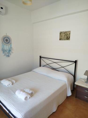 a bedroom with a white bed with towels on it at Nereids Apartments-Agavi in Petalidi