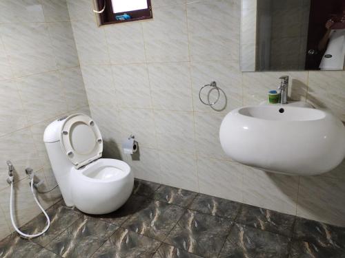 ein Badezimmer mit einer weißen Toilette und einem Waschbecken in der Unterkunft Glen Villa Holiday Home - Galle in Galle