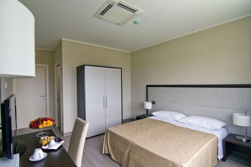 レンデにあるGalileo B&Bのベッド、デスク、テレビが備わるホテルルームです。