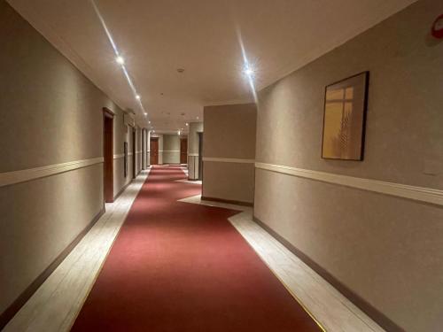 an empty hallway with a red carpet in a building at Wakra Inn Hotel Apartments in Al Wakrah