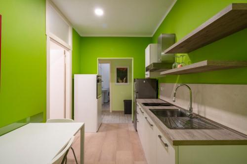una cocina verde con fregadero y encimera en Appartamento a due passi dal mare. Civitanova M., en Civitanova Marche
