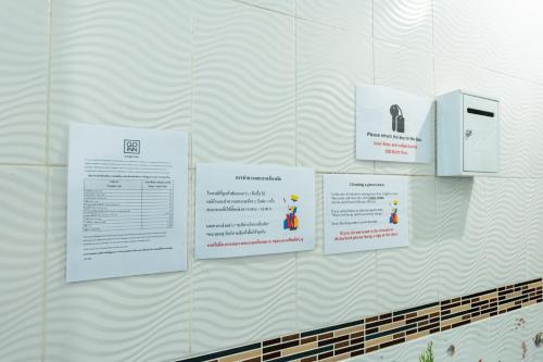 a wall with signs hanging on a wall at xxThe Hidden Giant Swing เดอะ ฮิดเด้น เสาชิงช้า in Bangkok