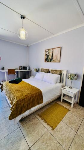 a bedroom with a large bed with a yellow blanket at O'Meara Overnight Rooms in Kimberley