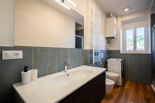 un baño con lavabo e inodoro en Suite in Greve for 4 guests Wi-Fi, washing machine, and AC, en Greve in Chianti