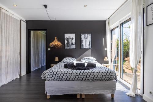 una camera da letto con un grande letto con pareti nere di Villa spacieuse avec piscine privée à Toulouse a Tolosa