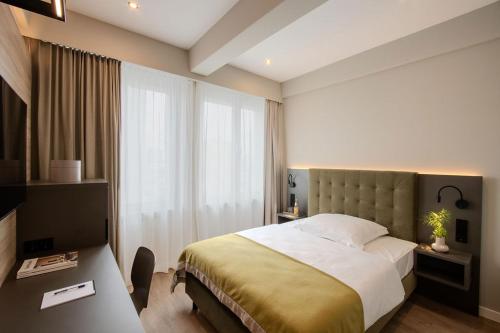 ein Schlafzimmer mit einem Bett und einem großen Fenster in der Unterkunft East Five Hotel in Offenbach