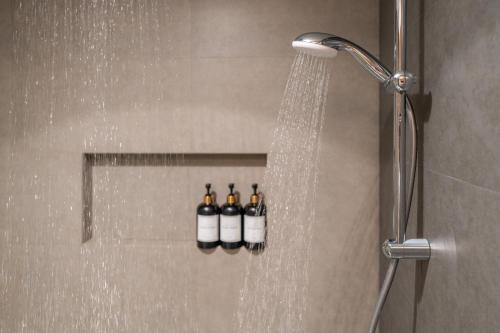 a shower with four bottles of wine in a bathroom at Lazzlla1BR Beachfront Oceanfront Apartment in Male City