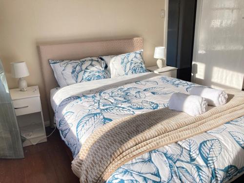 a bed with blue and white sheets and pillows at Oceans Edge Three-bed rooms spacious house in Bluff in Bluff