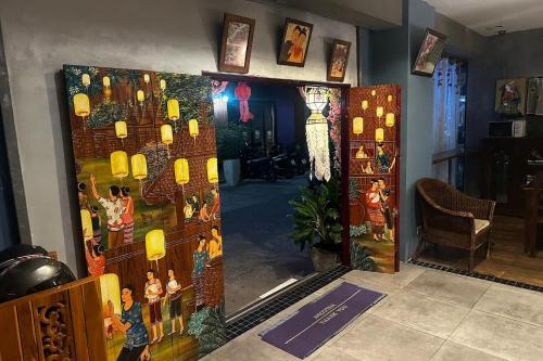 an entrance to a room with a door with a painting on it at SawasdeeCiao Patong Guesthouse in Patong Beach