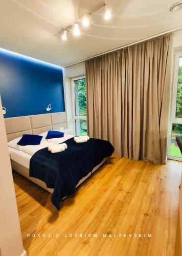 a bedroom with a bed and a blue wall at Szafir in Rogoźnik