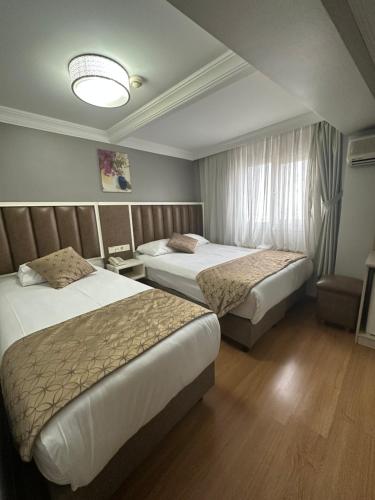a hotel room with two beds and a window at Hotel Süreyya in Istanbul