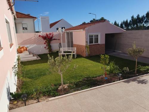 a small yard with a house with a lawn at Casa do Arelho in Bicas