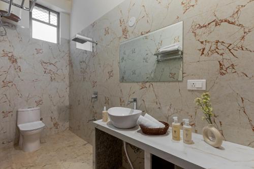 une salle de bain avec un lavabo et des toilettes dans l'établissement SaffronStays Raaga, à Udaipur
