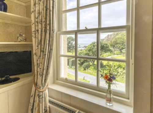 a window with a vase of flowers on a window sill at Knockinaam Lodge in Portpatrick