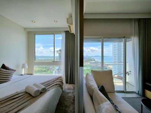 une chambre d'hôtel avec un lit et une grande fenêtre dans l'établissement 1 Bedroom Condo R272 Veranda Pattaya Beachfront, à Na Jomtien