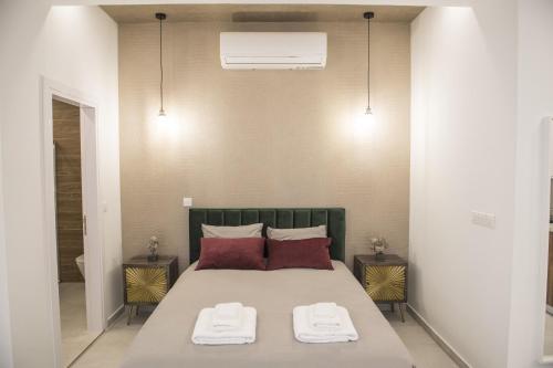 ニコシアにあるSTAY Glam Skin Studioのベッドとタオル2枚のある寝室