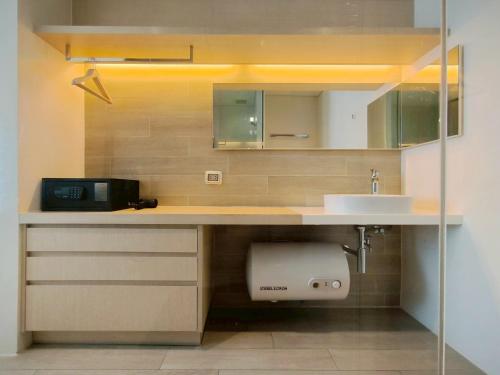 une cuisine avec un comptoir avec un évier et un micro-ondes dans l'établissement 1 Bedroom Condo R272 Veranda Pattaya Beachfront, à Na Jomtien