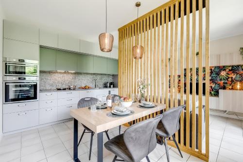 a kitchen with a table and chairs in a room at Superior Village Apartments - Porto Letizia in Porlezza