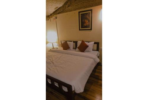 a bedroom with a bed with white sheets and pillows at Shikaar Valley in Khilchipur