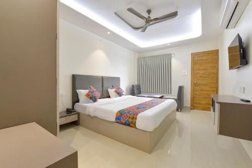 Un dormitorio con una cama grande con techo. en FabHotel Synergy Stays, en Indore