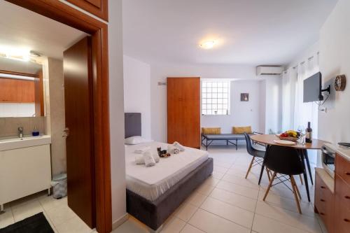 a room with a bed and a table and a kitchen at Venetian Studio in the Centre 1 in Heraklio