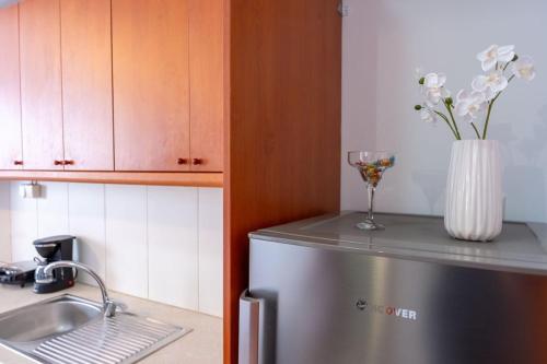 a kitchen with a refrigerator and a vase with flowers at Venetian Studio in the Centre 1 in Heraklio