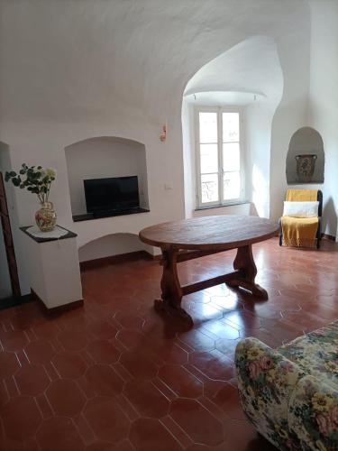 a living room with a wooden table and a couch at House of the Arches in Castelbianco