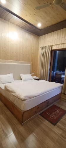 a large bed in a room with a window at Harshvan resort in Chakrāta
