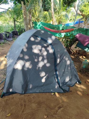 a blue tent sitting on the ground in the dirt at Sanchari hostel in Kuilapayam