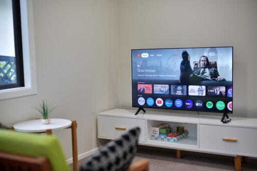 a flat screen tv sitting on top of a white cabinet at Family Friendly 1BR in Howick, Near Beach and Cafes in Auckland