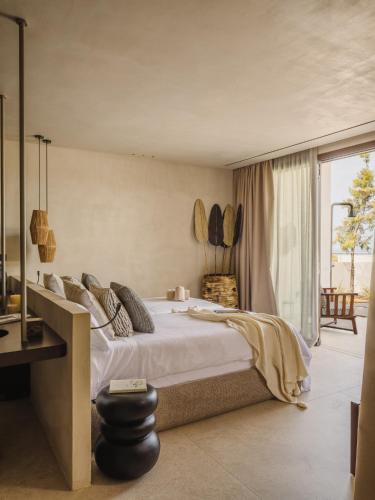 a bedroom with a large bed and a balcony at Serendi Villas in San Antonio