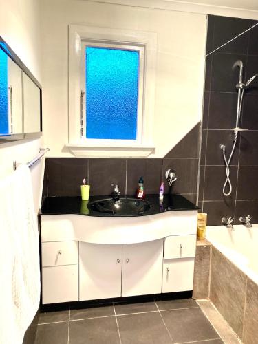 a bathroom with a sink and a tub and a window at Oceans Edge Three-bed rooms spacious house in Bluff in Bluff