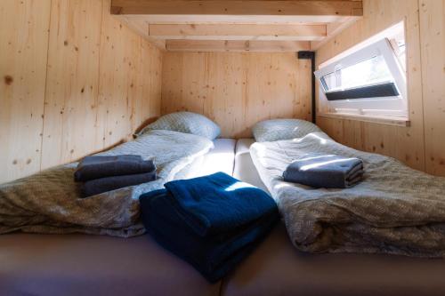 NeuwerkにあるTinyhouse Wald-Fritzlのキャビン内のツインベッド2台が備わる客室です。