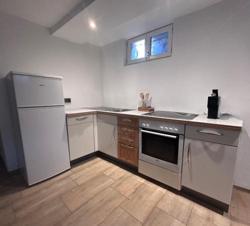 a kitchen with a stove and a refrigerator at Montage- Pendlerwohnung in Kandern