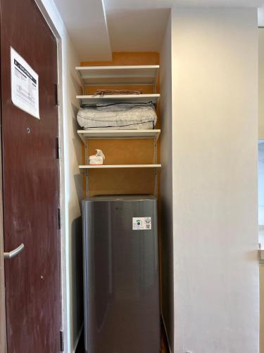 a small refrigerator in a room with a door at Sky House Studio Apartment in CBD BSD near AEON and ICE in Cilenggang