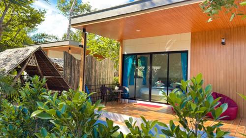 a home with a deck with a table and chairs at Ao Nang Escapes Tropical Villas & Studios in Ao Nang Beach