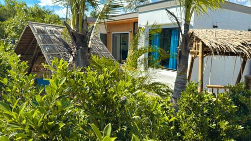 a house with a palm tree in front of it at Ao Nang Escapes Tropical Villas & Studios in Ao Nang Beach