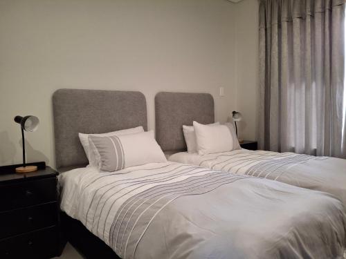 two beds with white pillows in a bedroom at Arbre Stay at 1 ON YORK in George