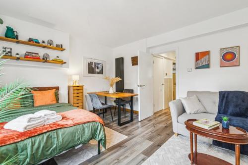 a bedroom with a bed and a couch and a table at Deluxe Studio Flat - King's Cross - by KeyHol Holiday Let in London