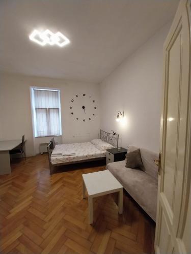Habitación con cama, sofá y reloj en la pared en CENTRAL Inn Zagreb, en Zagreb