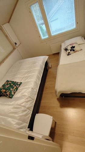 two twin beds in a small room with a window at Rauhallinen rivitalo in Kilvakkala